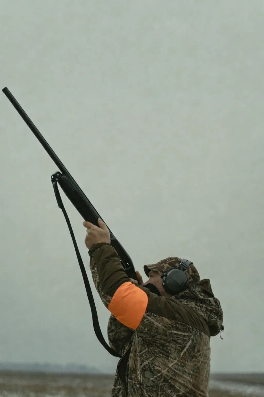 Shooter and precision sports participant wearing Hypear custom hearing protection with impulse filter technology - protecting hearing from gunshots and loud impacts while allowing communication and ambient sound awareness